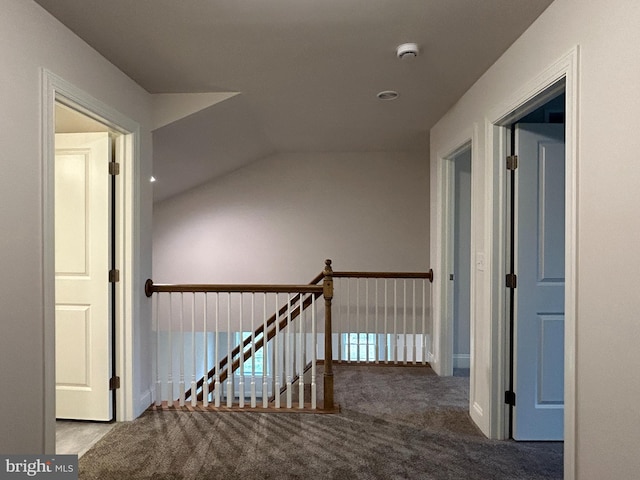 hall featuring carpet and lofted ceiling