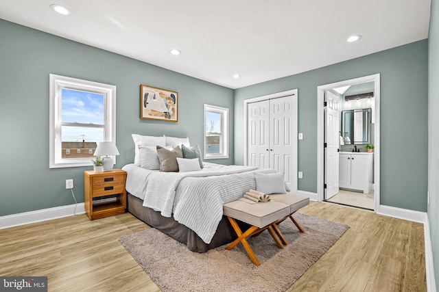 bedroom featuring ensuite bathroom, a closet, light hardwood / wood-style floors, and sink