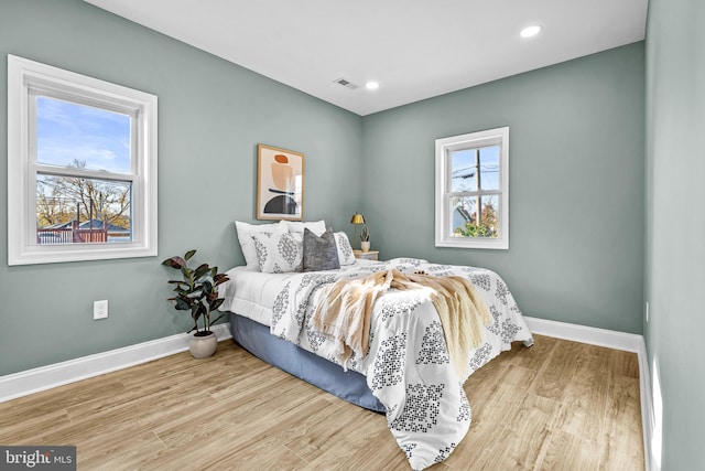 bedroom featuring light wood-type flooring and multiple windows