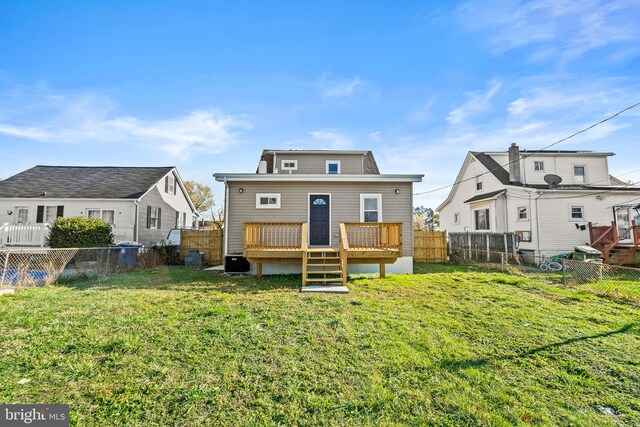 rear view of house featuring a yard and a deck