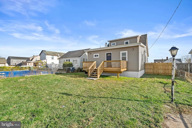 rear view of property featuring a deck and a yard