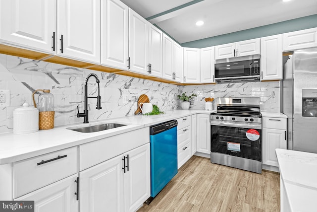 kitchen with white cabinets, stainless steel appliances, tasteful backsplash, and sink