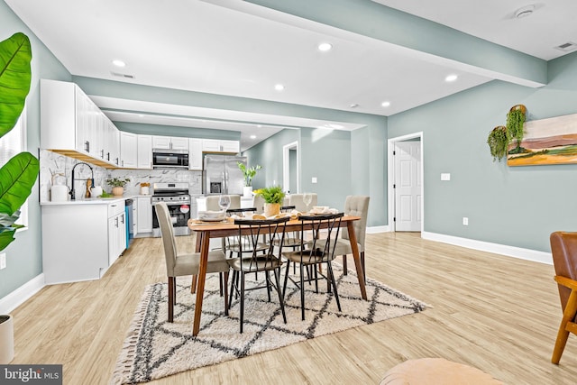 dining space with sink and light hardwood / wood-style floors