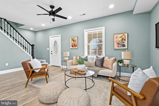 living room with light hardwood / wood-style flooring and ceiling fan