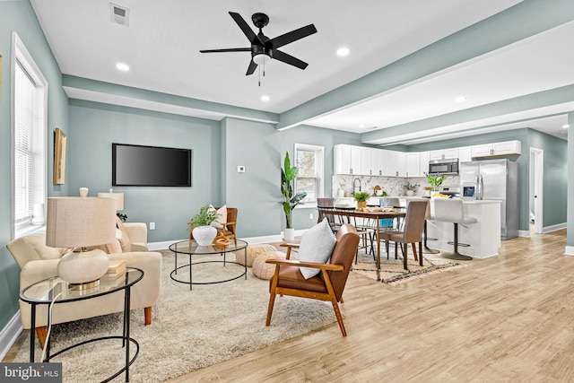 living room featuring ceiling fan and light hardwood / wood-style floors