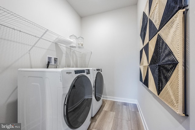 laundry area with light hardwood / wood-style flooring and independent washer and dryer