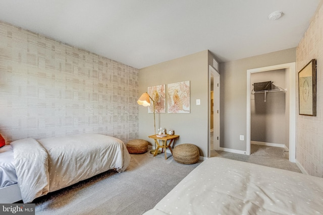 carpeted bedroom featuring a walk in closet and a closet