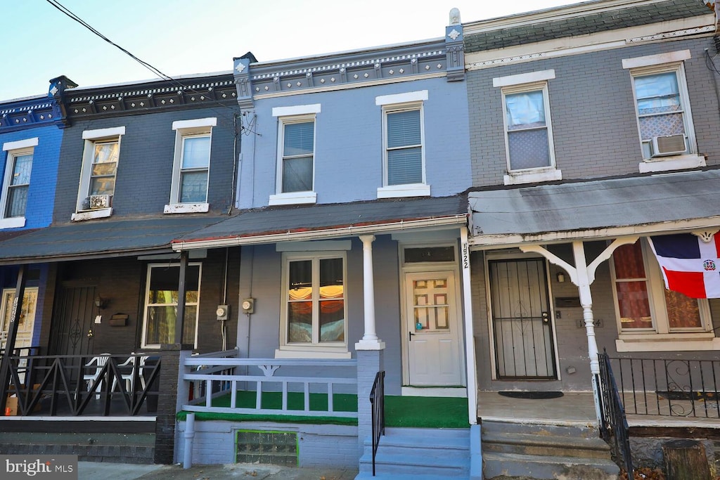 1922 Dennie St, Philadelphia, PA 19140 - view of property featuring covered porch, brick siding, and cooling unit