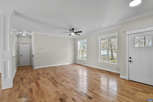 entrance foyer with a healthy amount of sunlight, light hardwood / wood-style floors, and ornamental molding