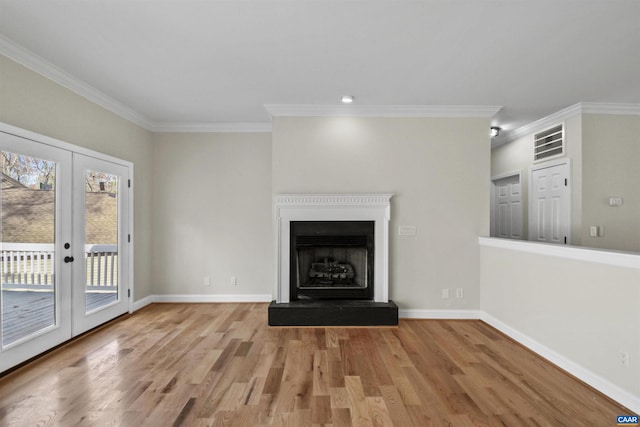 unfurnished living room with french doors, light hardwood / wood-style floors, and crown molding