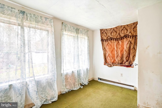 empty room with baseboard heating and carpet floors