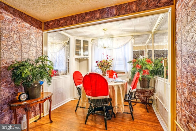 dining space with a chandelier, hardwood / wood-style floors, and a textured ceiling