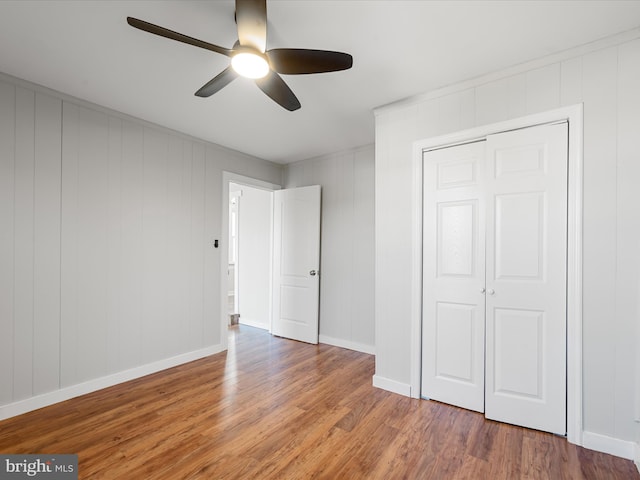 unfurnished bedroom featuring hardwood / wood-style floors, ceiling fan, and a closet