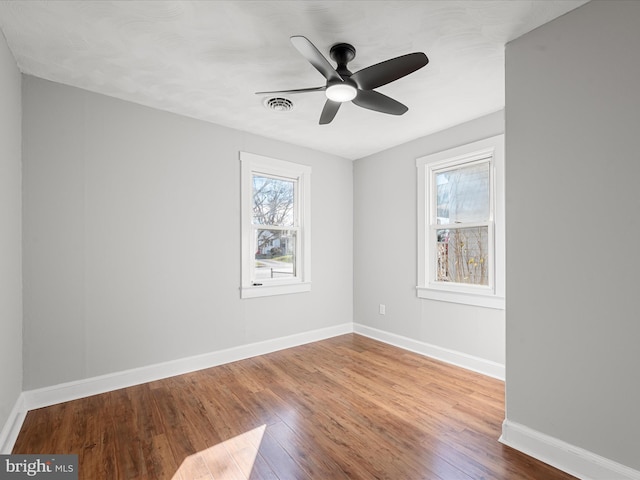 spare room with hardwood / wood-style floors and ceiling fan