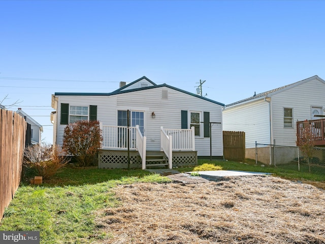 back of property featuring a yard and a deck