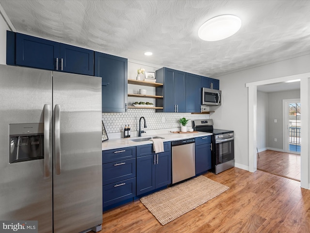 kitchen featuring light hardwood / wood-style floors, sink, blue cabinets, and stainless steel appliances