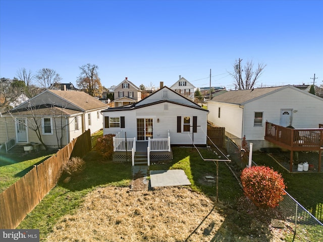 back of house with a deck and a yard