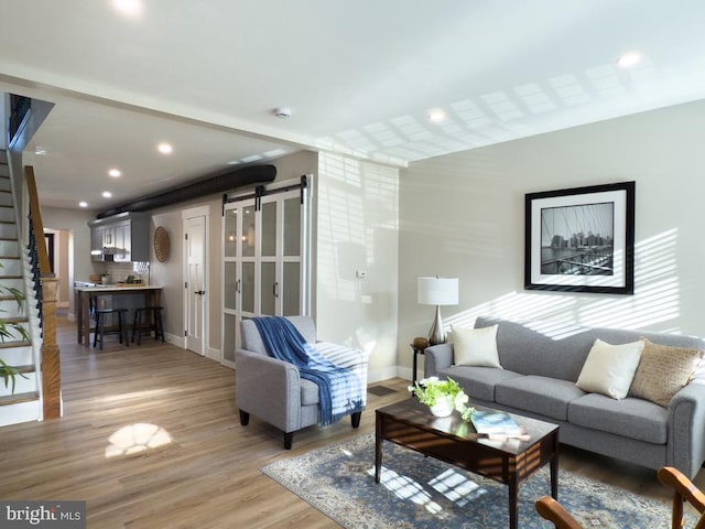 living room featuring a barn door and hardwood / wood-style flooring