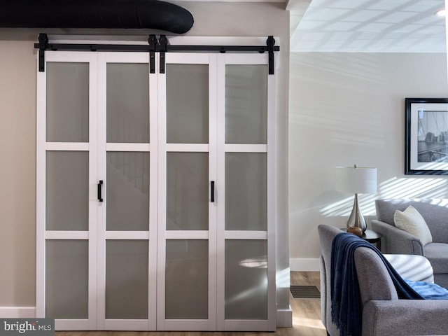 interior details with a barn door and hardwood / wood-style flooring