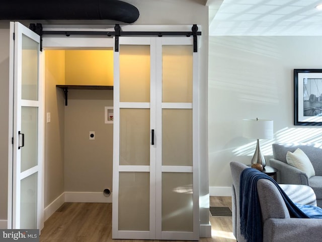 interior space with a barn door and hardwood / wood-style floors