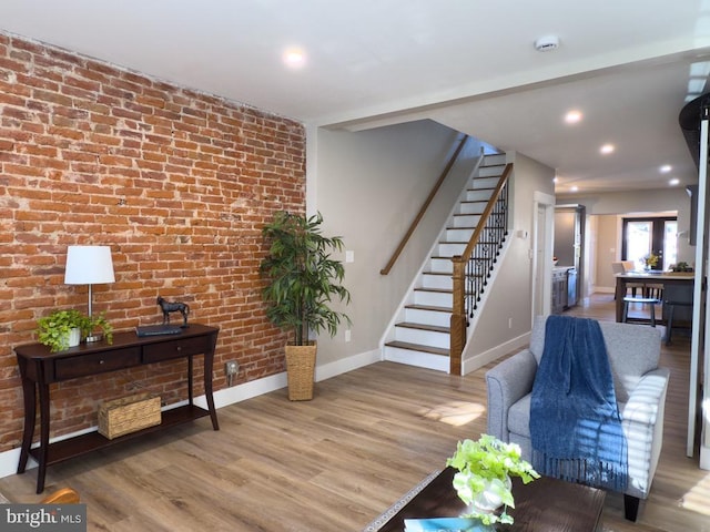 living room featuring hardwood / wood-style flooring and brick wall