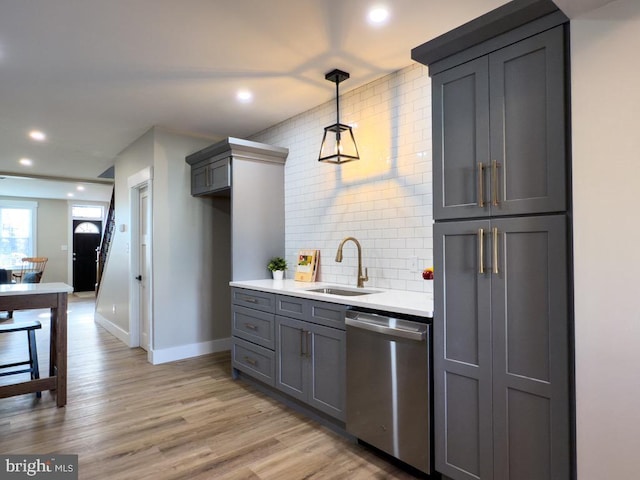 kitchen featuring gray cabinets, dishwasher, light hardwood / wood-style floors, and sink