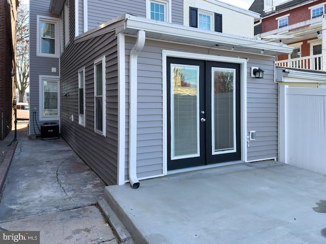 view of exterior entry featuring central AC, a patio, and french doors