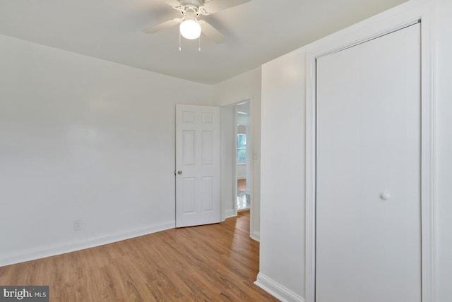 unfurnished bedroom with ceiling fan, a closet, and light hardwood / wood-style floors