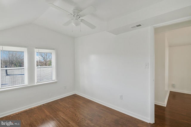 empty room with dark hardwood / wood-style flooring, vaulted ceiling, and ceiling fan