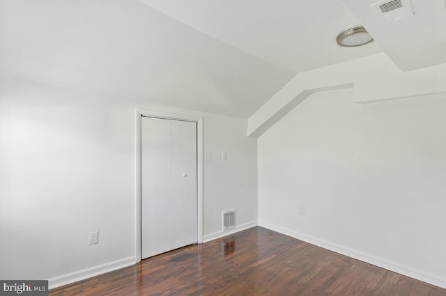 bonus room with dark wood-type flooring and vaulted ceiling