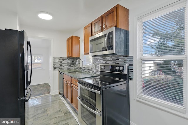 kitchen with appliances with stainless steel finishes, backsplash, and sink