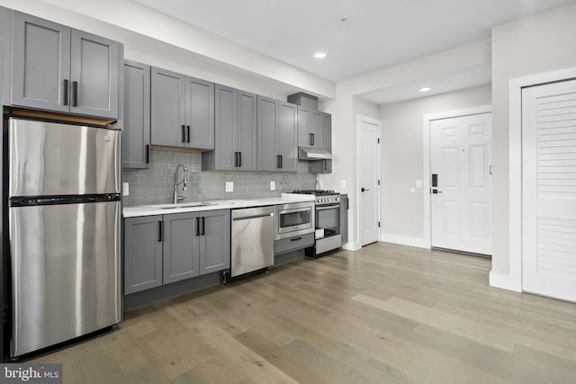 1028 Bladensburg Rd NE Unit 38, Washington, DC 20002 - kitchen featuring appliances with stainless steel finishes, a sink, light countertops, under cabinet range hood, and wood finished floors