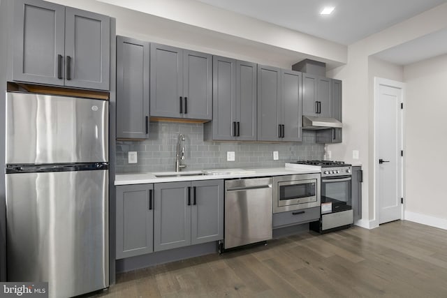 1028 Bladensburg Rd NE Unit 38, Washington, DC 20002 - kitchen with stainless steel appliances, a sink, under cabinet range hood, light countertops, and dark wood-style flooring
