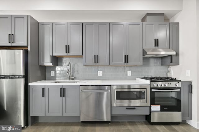 1028 Bladensburg Rd NE Unit 38, Washington, DC 20002 - kitchen with stainless steel appliances, a sink, under cabinet range hood, light countertops, and tasteful backsplash
