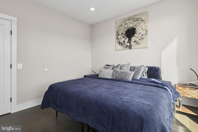 bedroom with dark hardwood / wood-style flooring