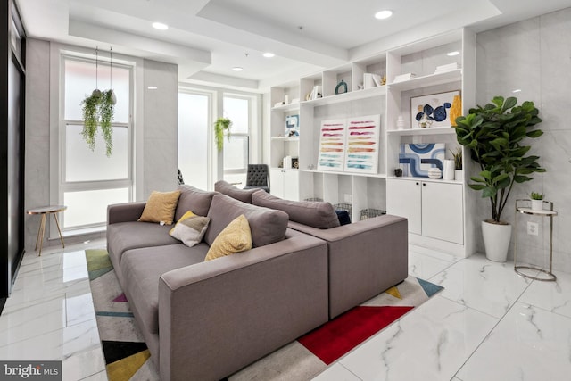 living room featuring built in features and a tray ceiling