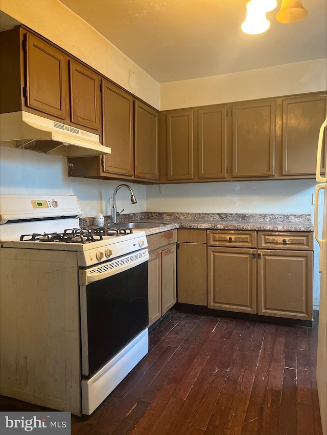 5131 Harlan St, Philadelphia, PA 19131 - kitchen with white range with gas stovetop, under cabinet range hood, dark wood-style floors, and a sink