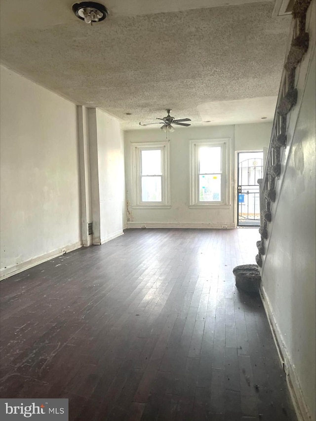 5131 Harlan St, Philadelphia, PA 19131 - unfurnished living room featuring dark wood-style floors, a ceiling fan, baseboards, a textured ceiling, and stairs