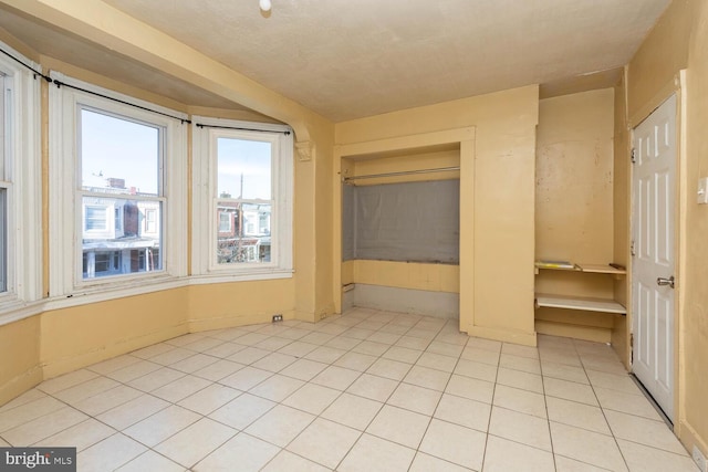 unfurnished bedroom with a closet and light tile patterned floors