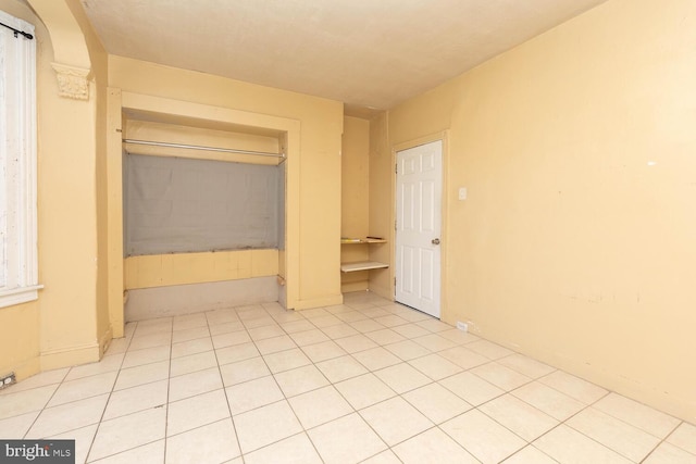 unfurnished bedroom featuring light tile patterned floors and a closet