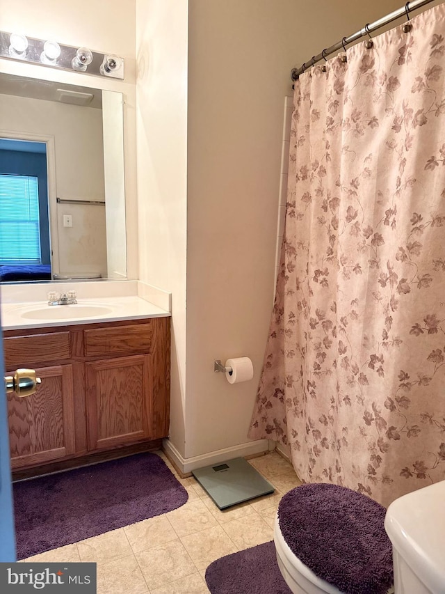 bathroom featuring tile patterned floors, vanity, toilet, and walk in shower