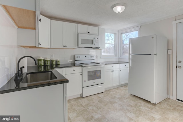 kitchen featuring white appliances, white cabinets, sink, a textured ceiling, and tasteful backsplash