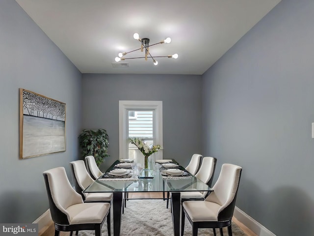 dining room featuring wood-type flooring and an inviting chandelier