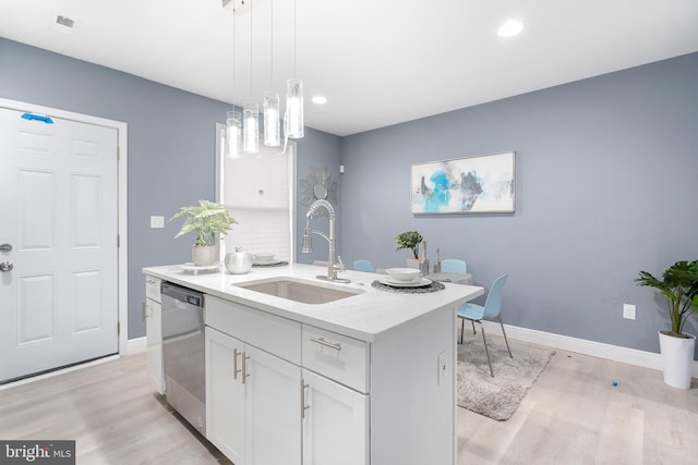 kitchen with dishwasher, a kitchen island with sink, white cabinets, sink, and light hardwood / wood-style floors