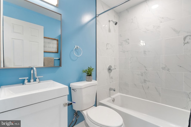 full bathroom featuring vanity, tiled shower / bath combo, and toilet