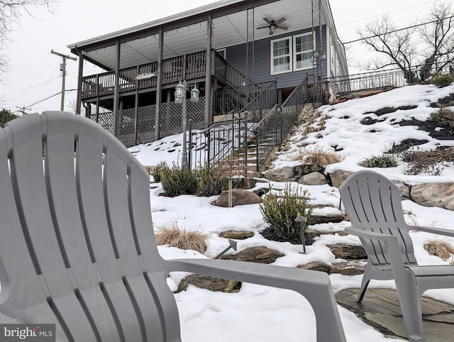 view of snow covered exterior with ceiling fan and stairs