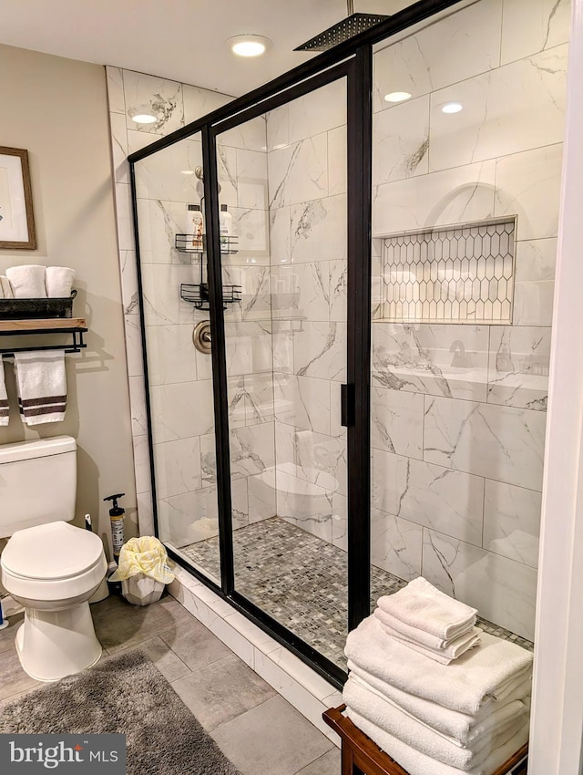 bathroom with toilet and a shower with shower door