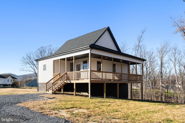 back of house with covered porch and a lawn