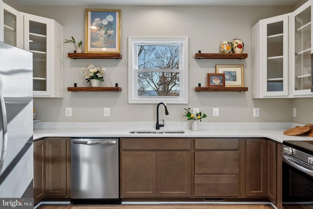 kitchen with appliances with stainless steel finishes, sink, and dark brown cabinetry