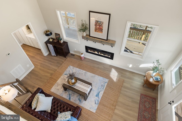 living room with a towering ceiling and wood-type flooring